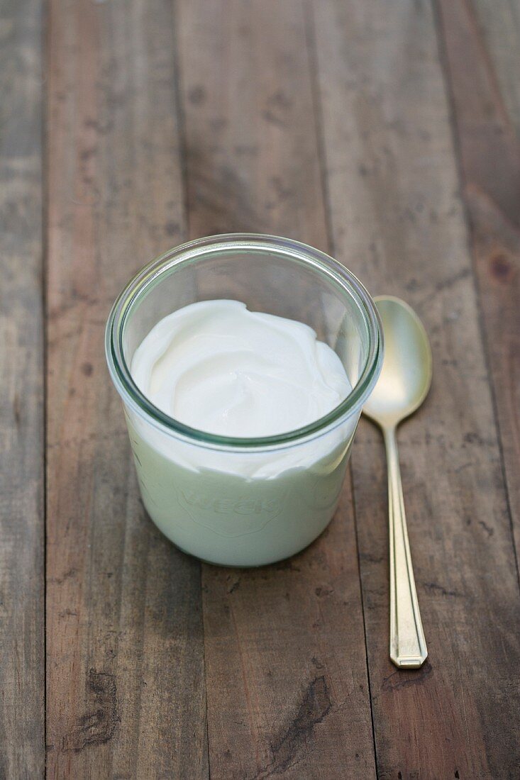 Naturjoghurt in Glas mit Teelöffel