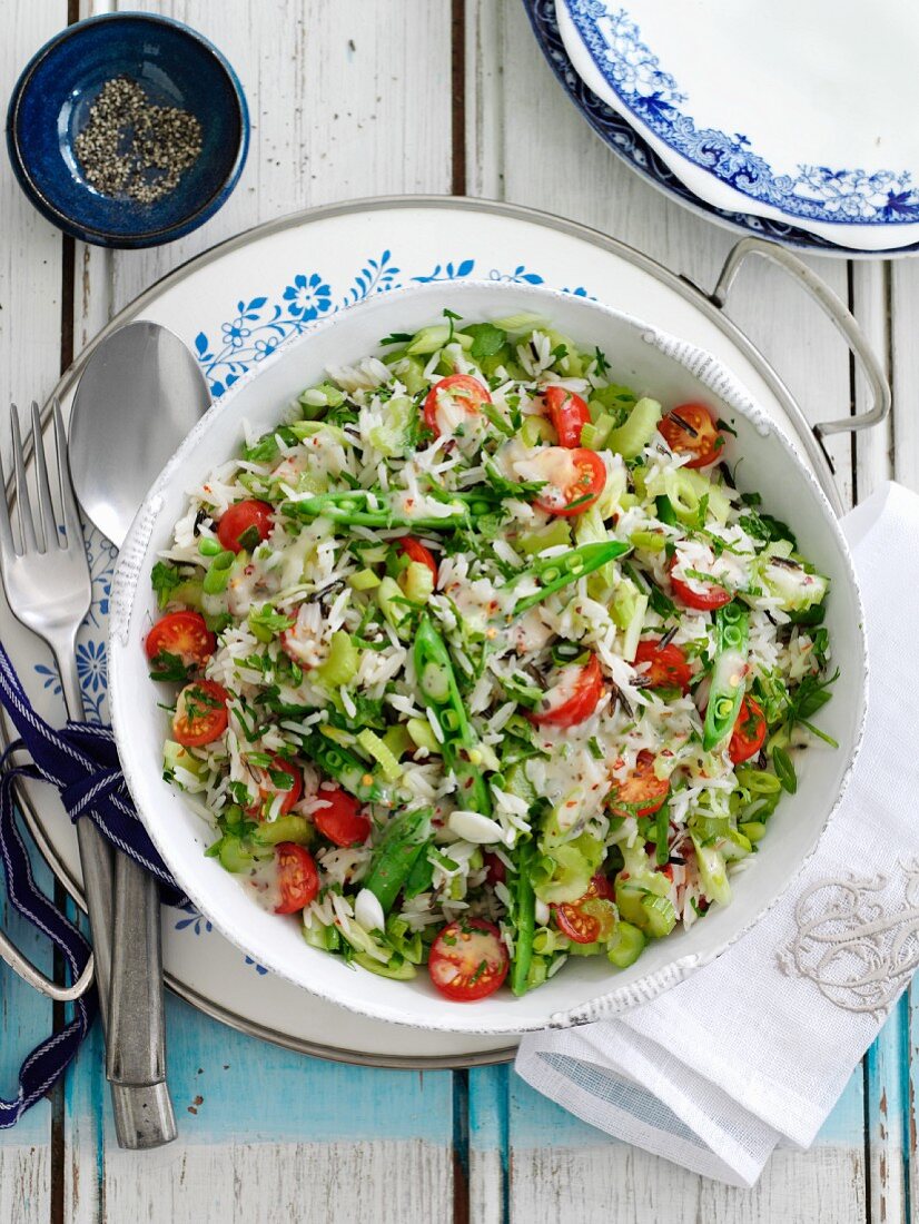 Vegetarian rice salad with tomatoes, celery and pea pods