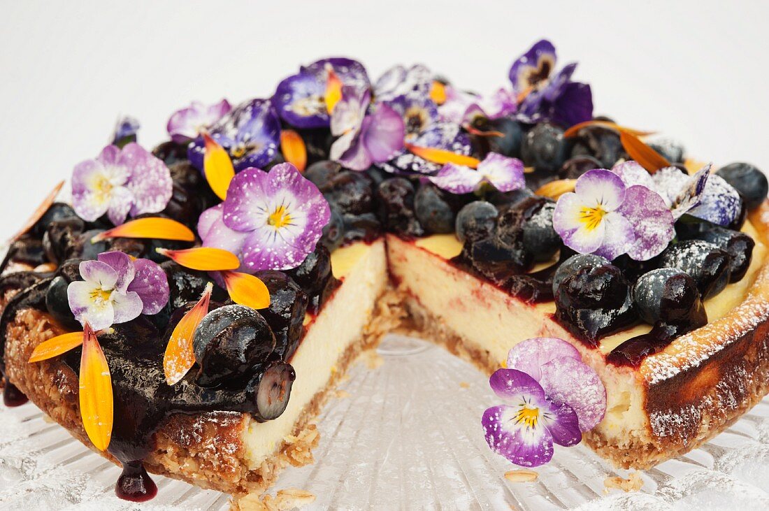 Heidelbeer-Käsekuchen mit Stiefmütterchen und Ringelblumenblüten