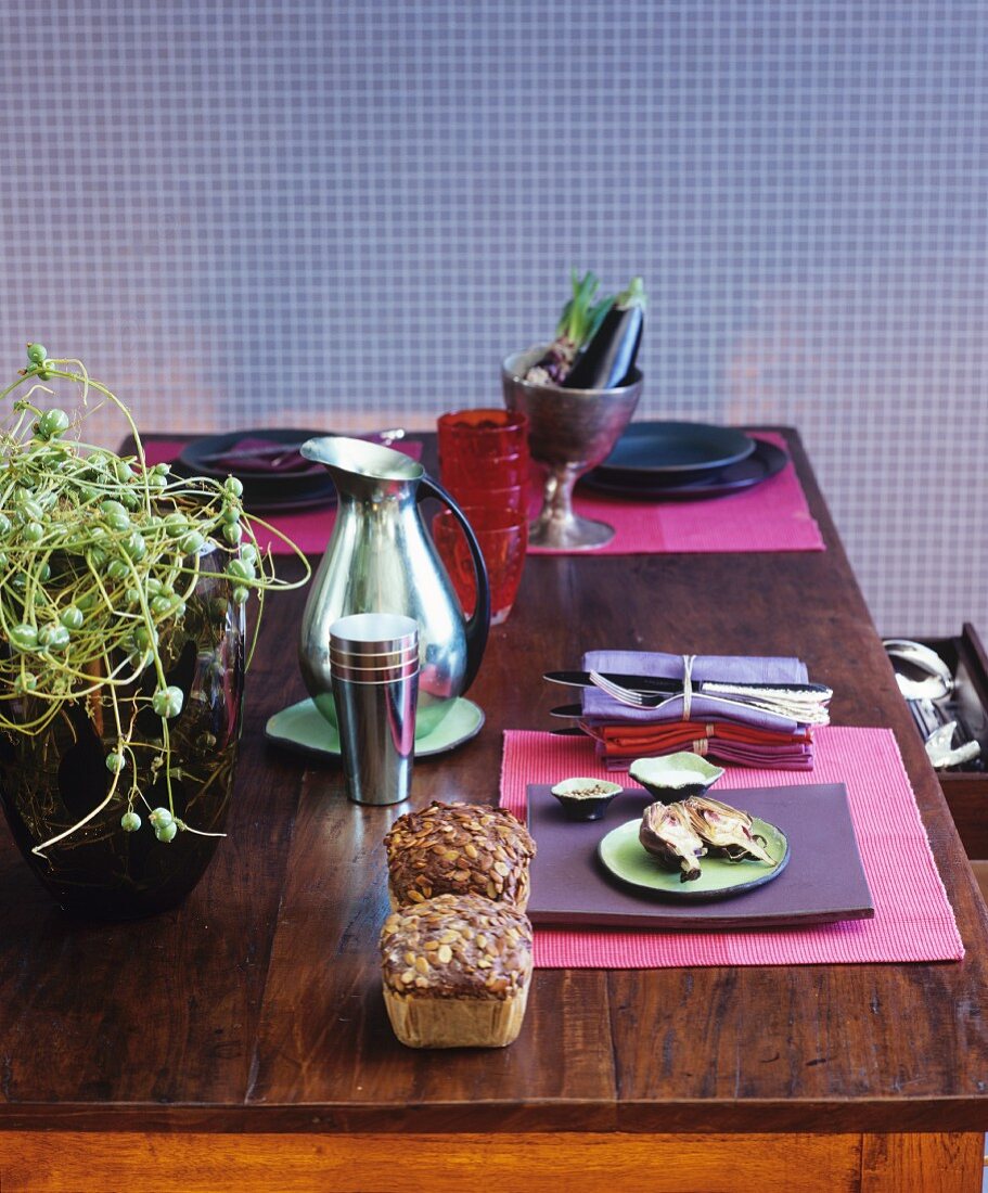 Herbstlich gedeckter Tisch mit gebratenen Artischocken und Brot