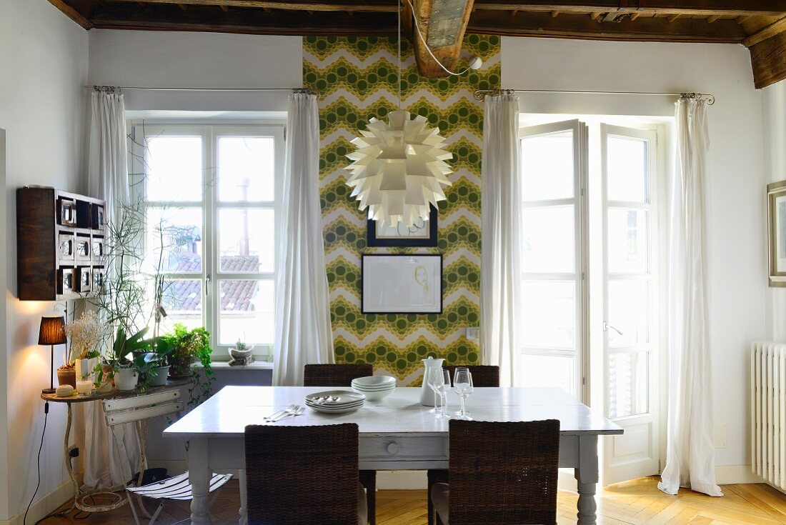 Dining area in front of retro wallpaper in period apartment