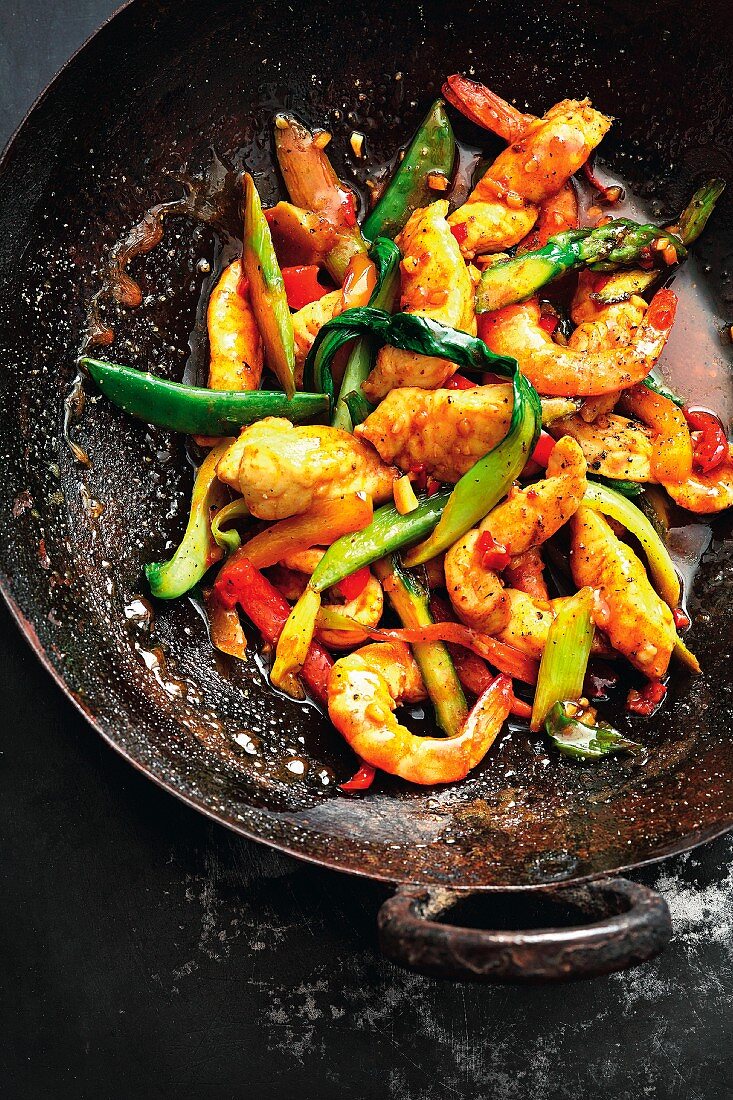 A wok with fillet of sole, prawns and sweet-and-sour vegetables
