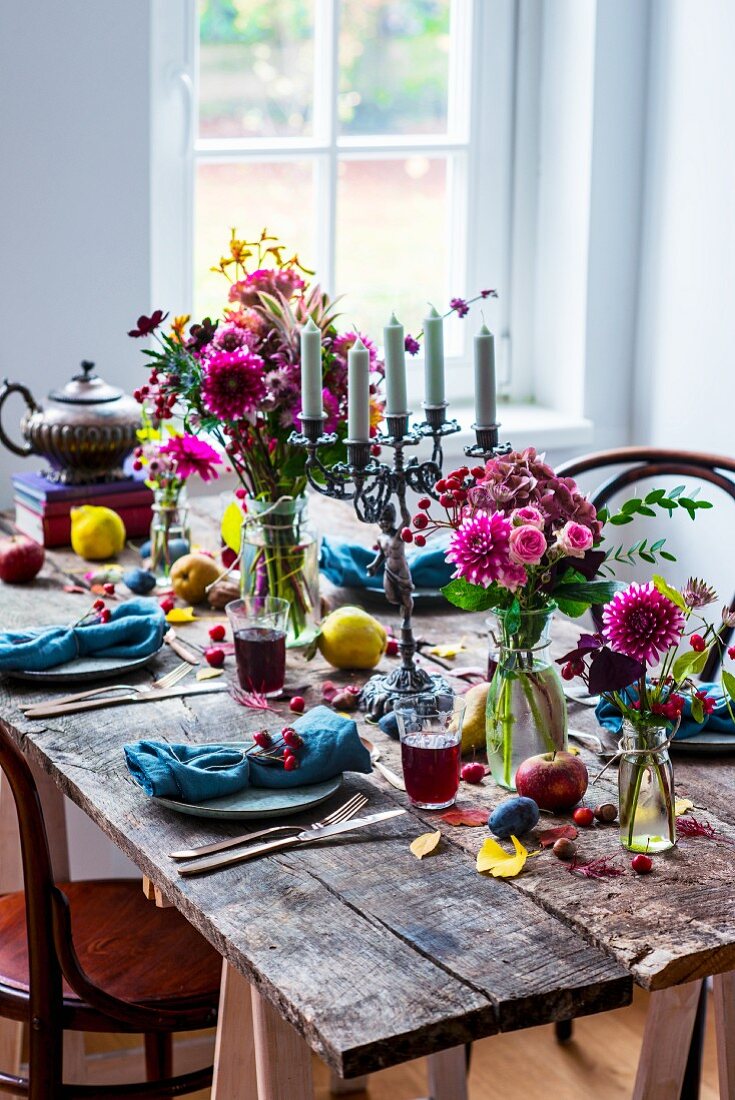Rustic arrangement of flowers and fruit on set wooden table