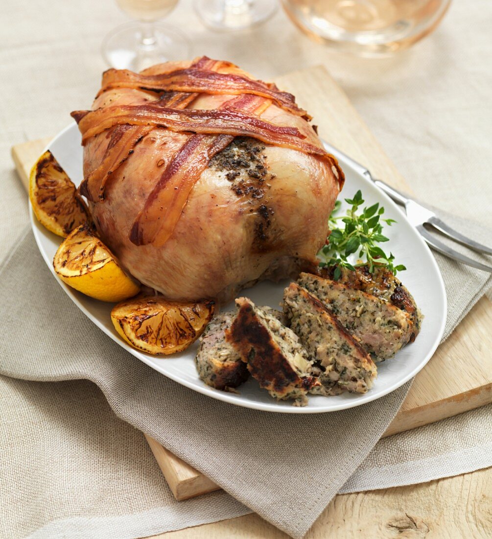 A roast chicken with strips of bacon