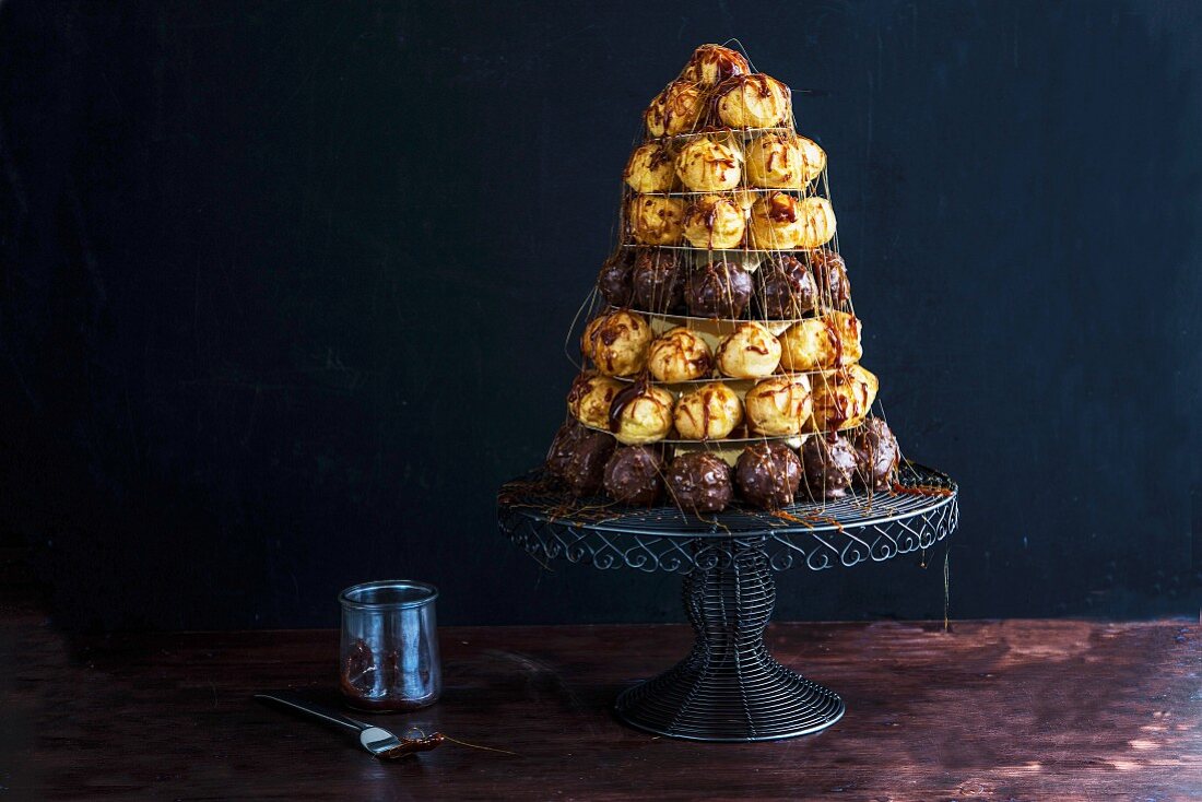 A croquembouche (a French dessert consisting of choux pastry balls bound with caramel threads) on a cake stand