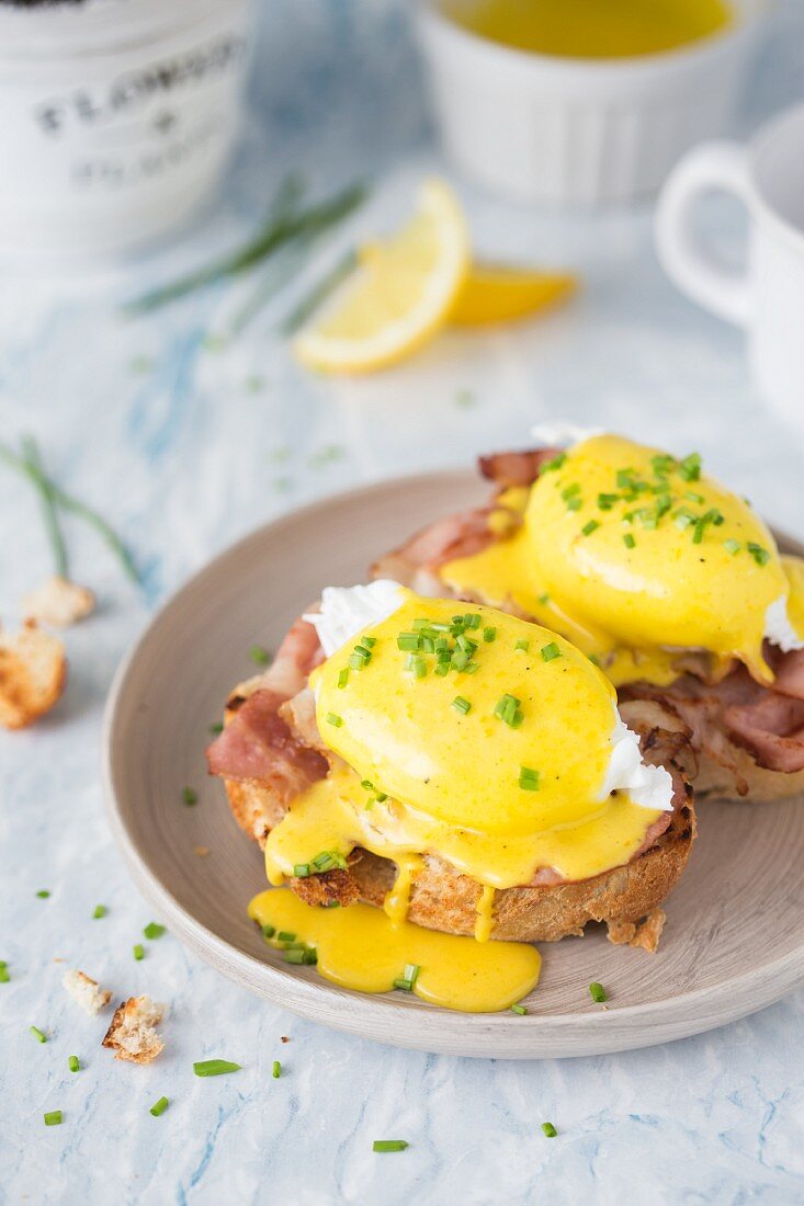 Eggs Benedict (poached eggs with crispy bacon and hollandaise sauce) on a toasted bread