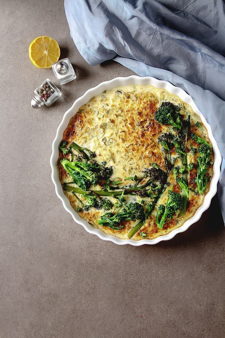 Vegetable quiche with broccoli and cheese in a white plate, Traditional French food