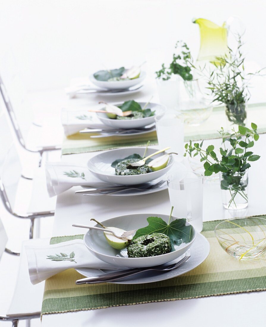 Gedeckter Tisch mit Kräuterkäse und Birnen