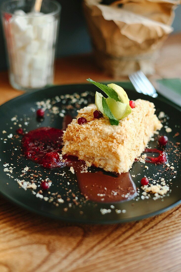 A piece of coconut cake with redcurrants and mint ice cream