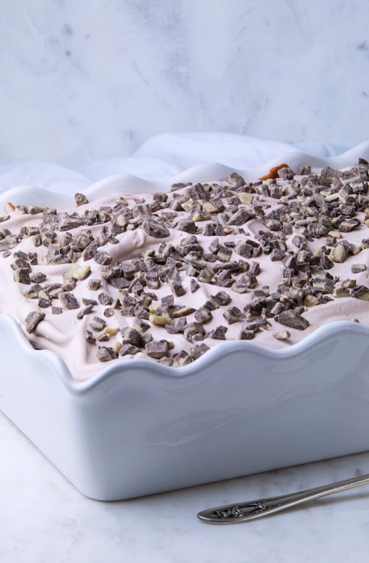 A creamy cake with chocolate chips in a white dish