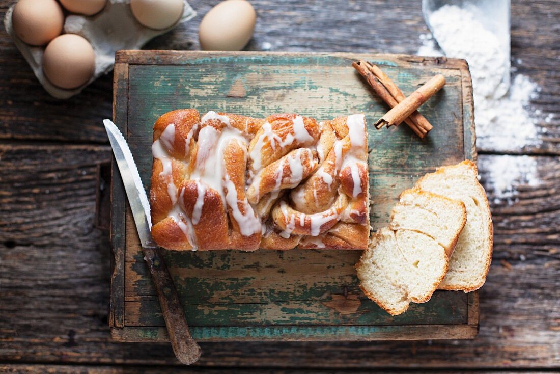 Hefe-Kastenkuchen mit Zimt und Zuckerglasur auf rustikalem Holzuntergrund