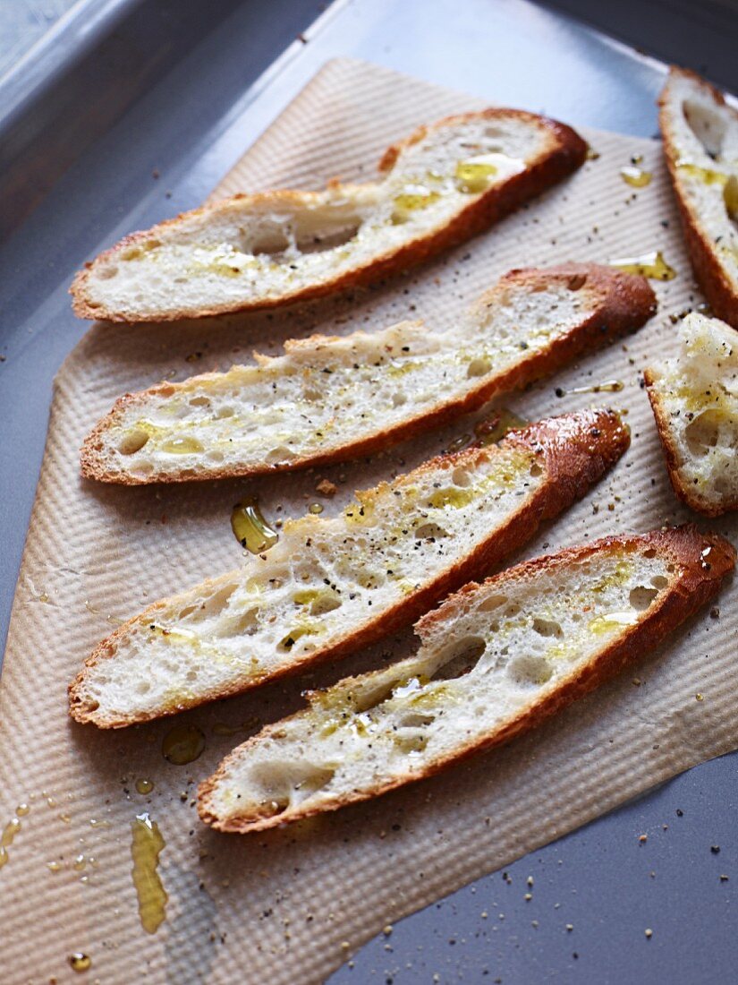 Toasted slices of bread drizzled with olive oil