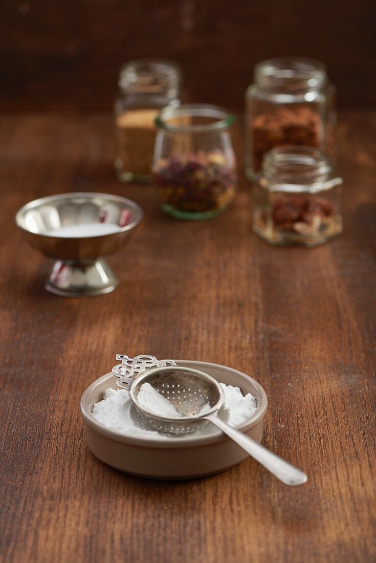 Icing sugar with a vintage sieve in a ceramic bowl