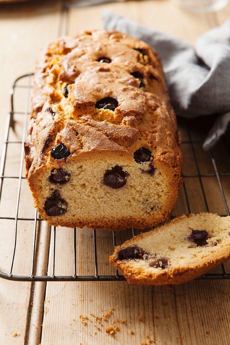 A sliced blueberry loaf cake on a wire cooling rack