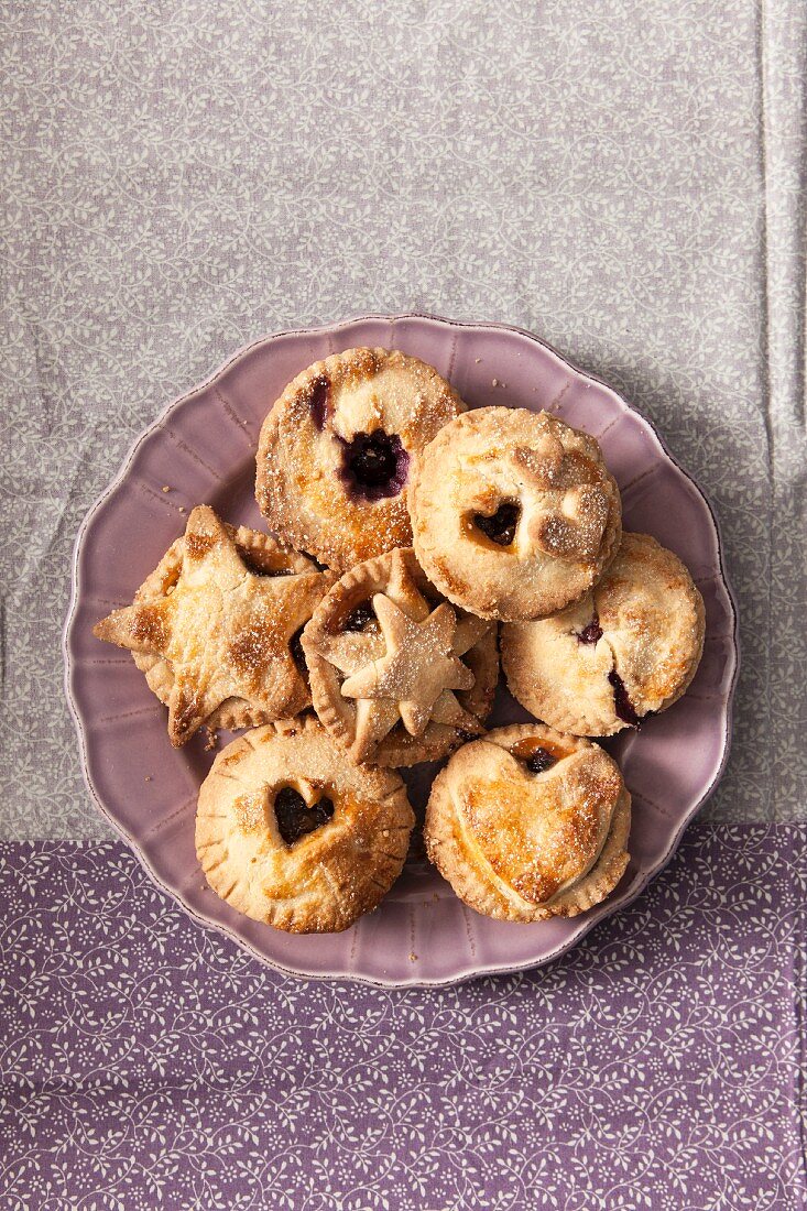 Small mince pies on a lilac plate (seen from above)
