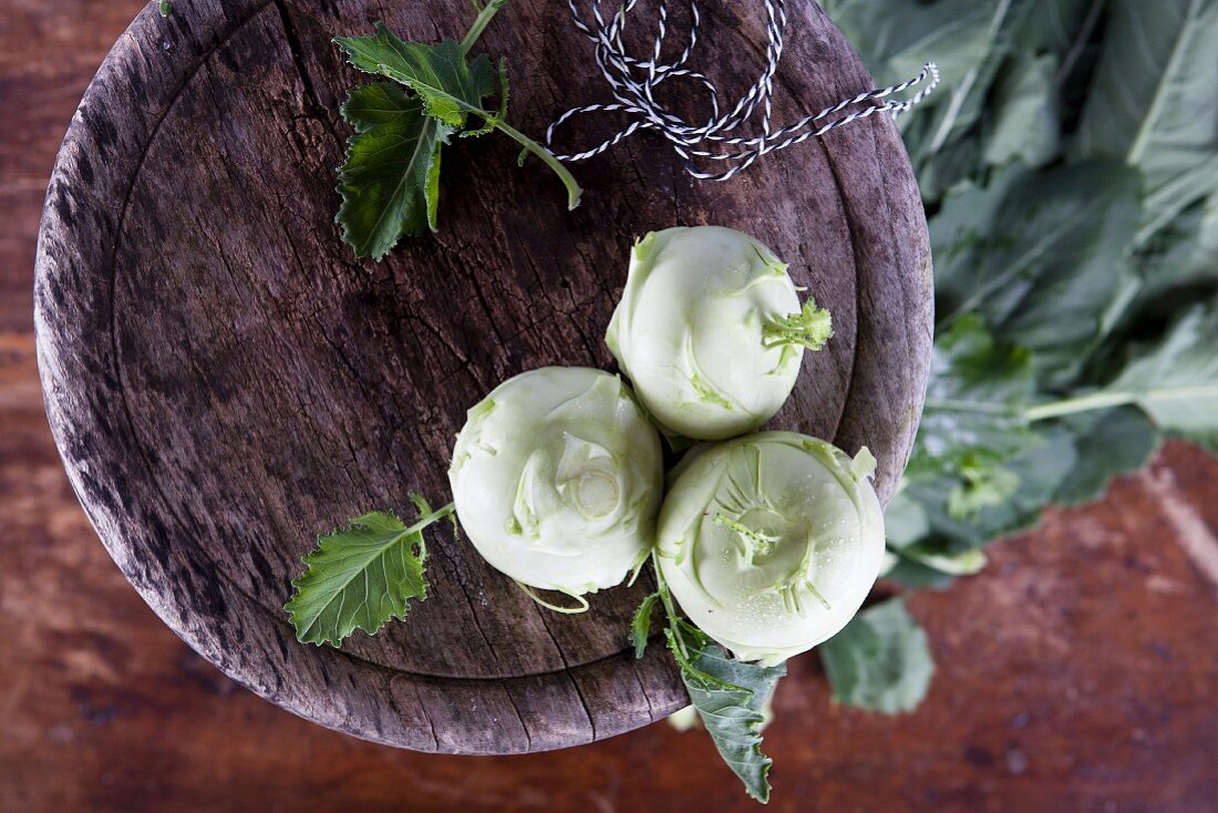 Three kohlrabi on a wooden stool