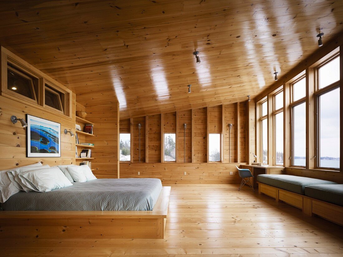 Double bed in spacious bedroom in wooden house