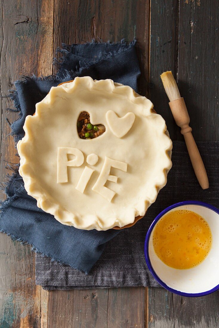 Fleischpie mit Schriftzug Pie und ausgestochenem Teigherz zubereiten