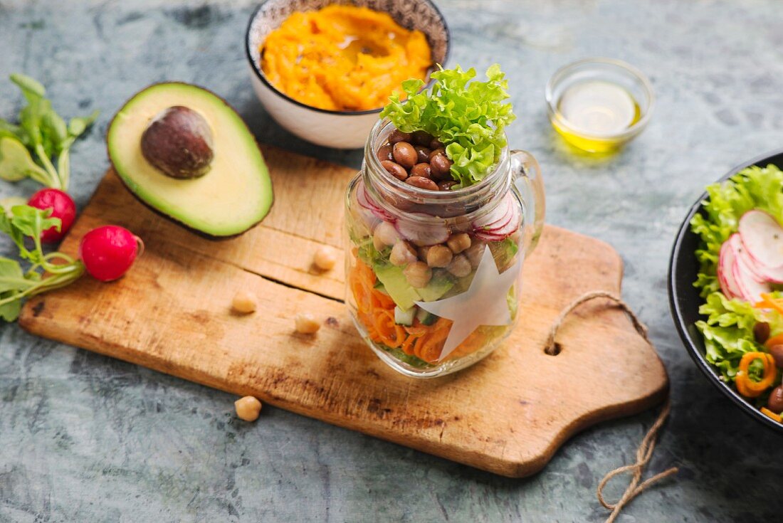 Mixed salad in a glass jar with sweet potato puree