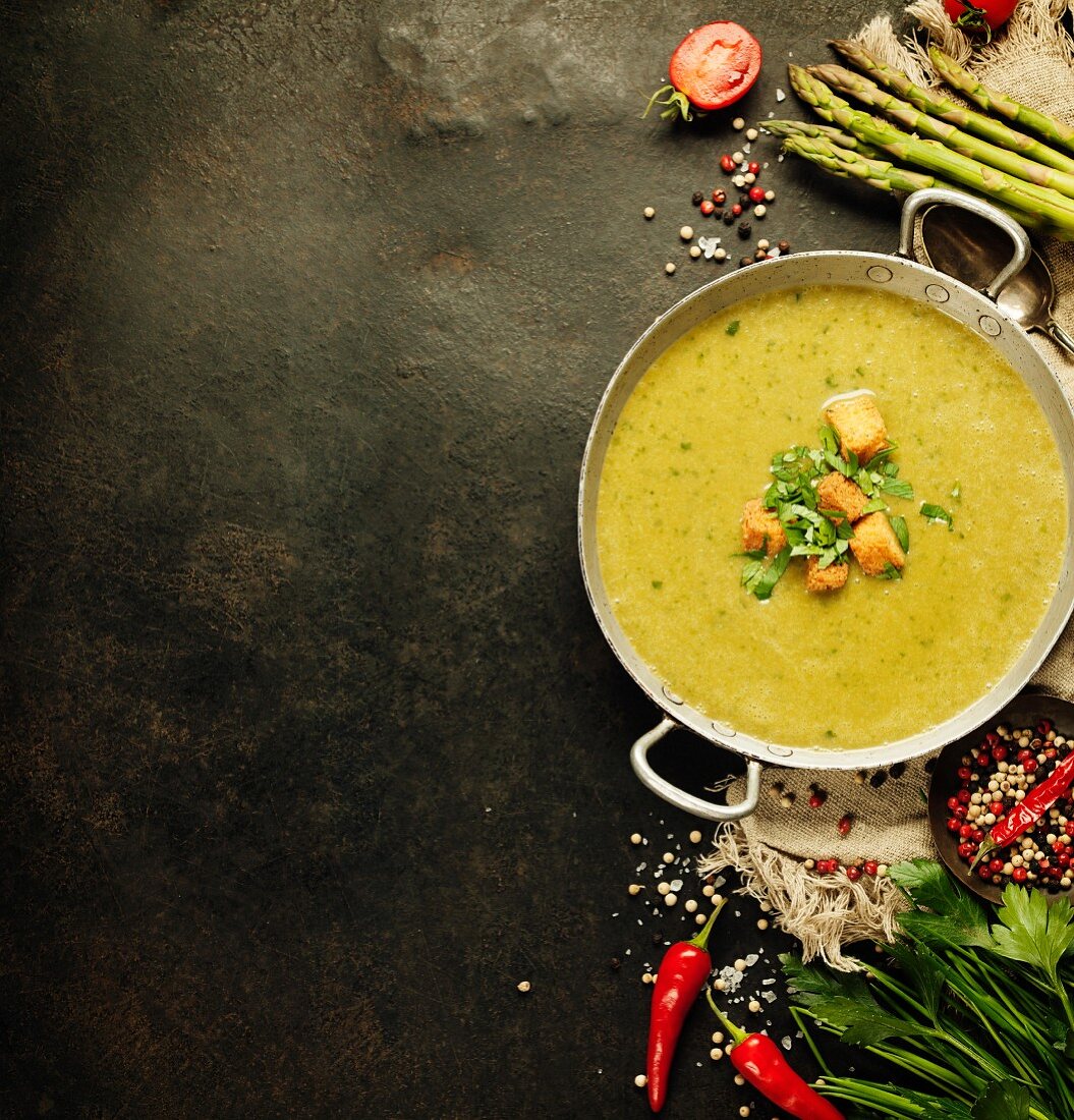 Asparagus cream soup on dark rustic background