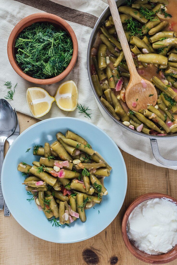 Fresh fava beans cooked with red onion, tomatoes, lemon juice and olive oil served in a light blue plate