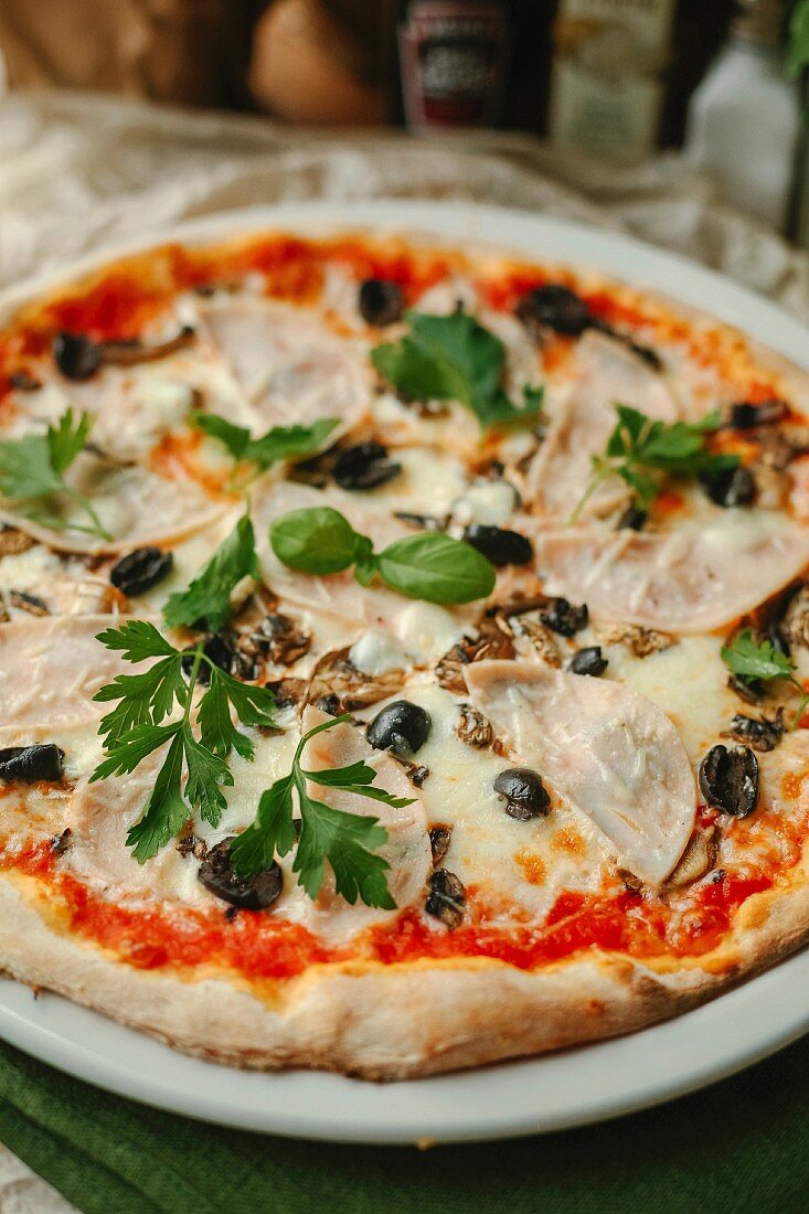 Pizza mit Schinken, Pilzen und Oliven