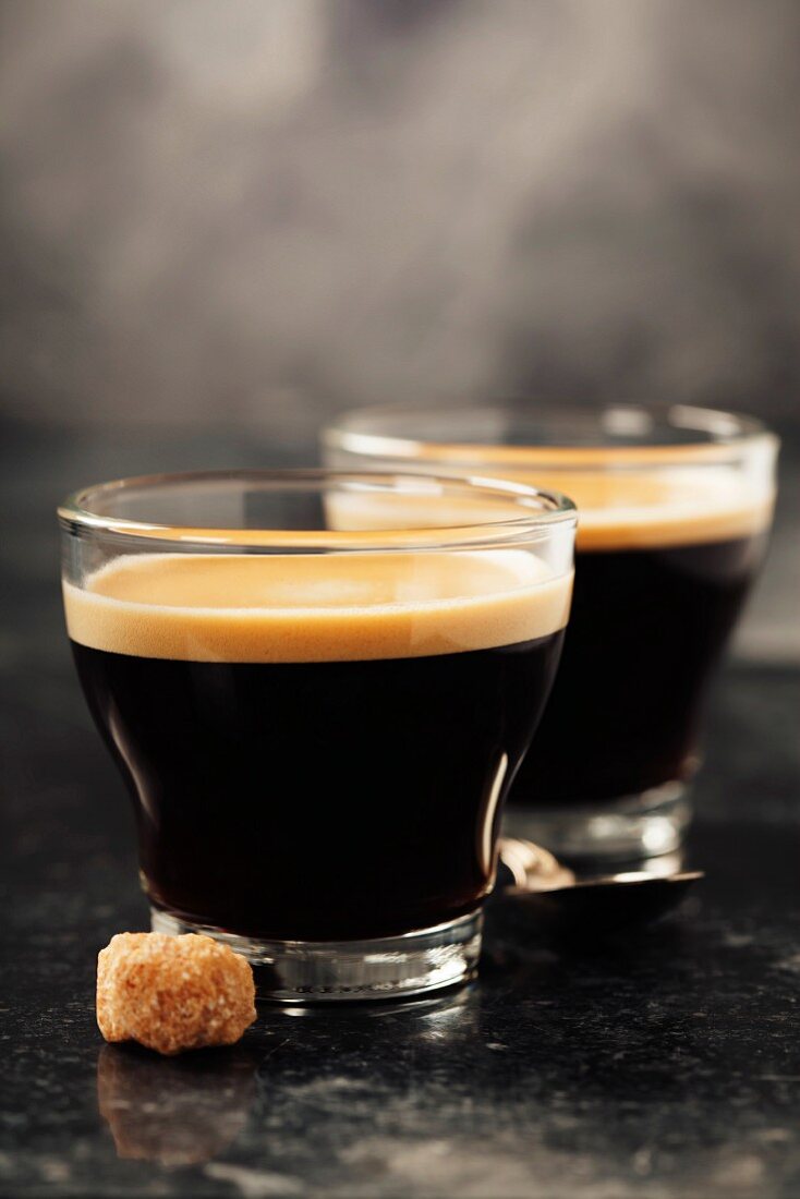 Cup of aromatic coffee over vintage table close up