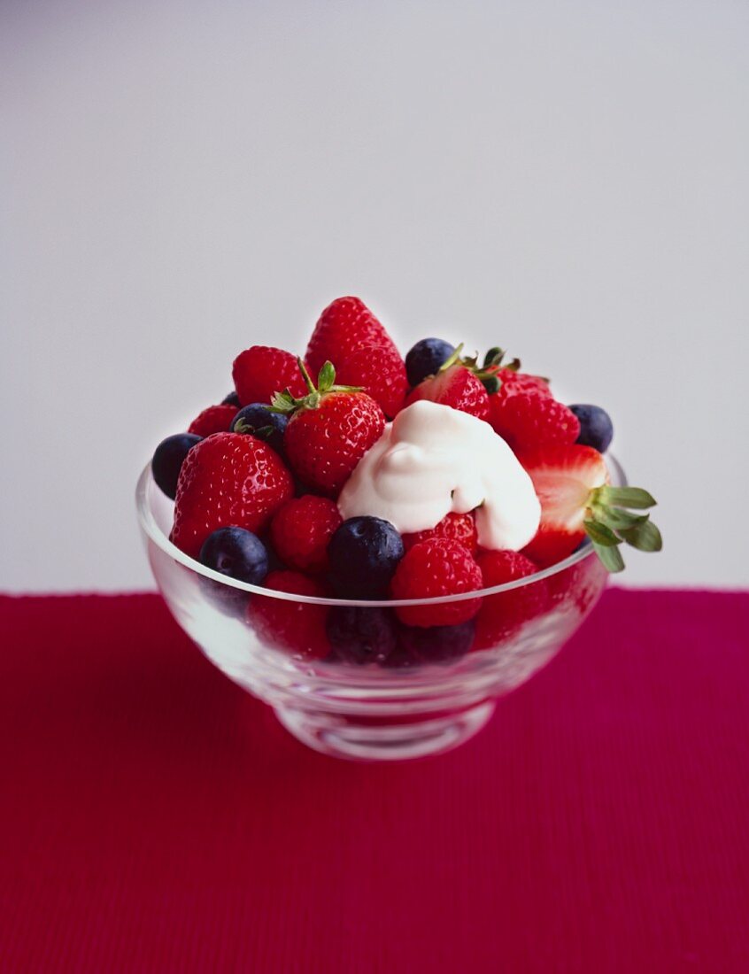 Fresh berries with cream in a dessert dish