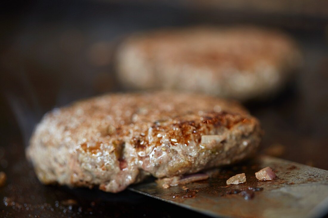 Hamburger auf dem Grill wenden