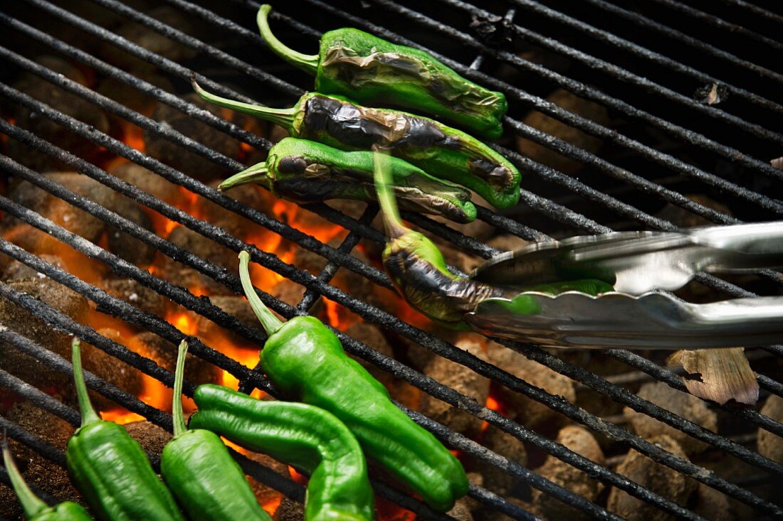 Green chilli peppers on a grill