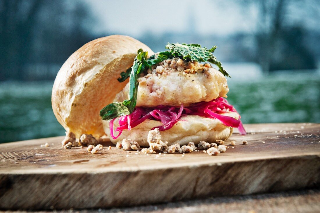 Burger with cabbage on a tree stump outdoors (camping)