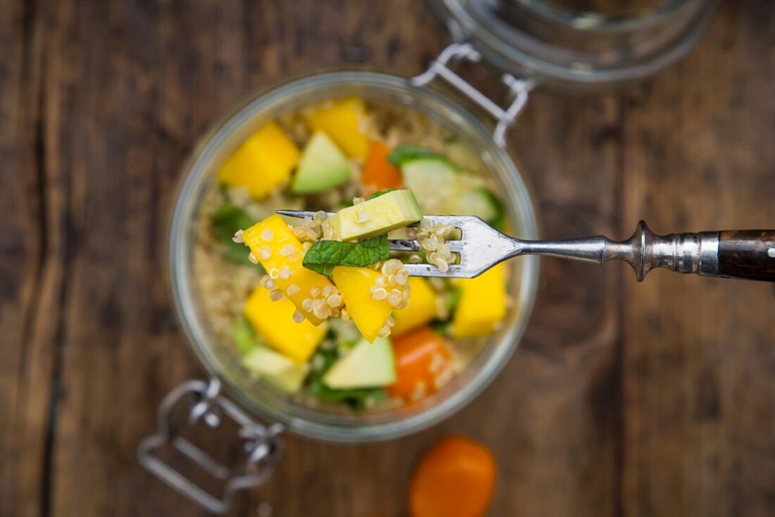 Quinoasalat mit Avocado, Gurke, Tomaten und Mango im Glas