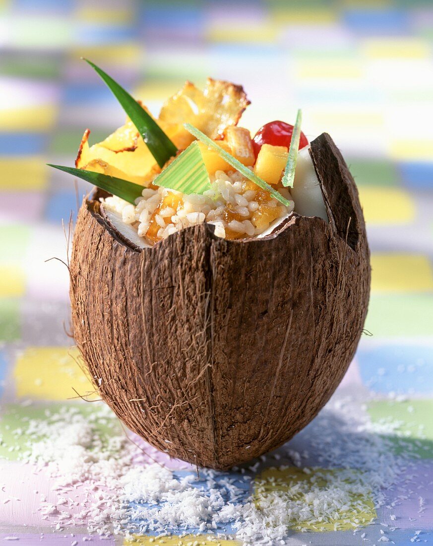 Rice pudding with candied fruits in a coconut husk