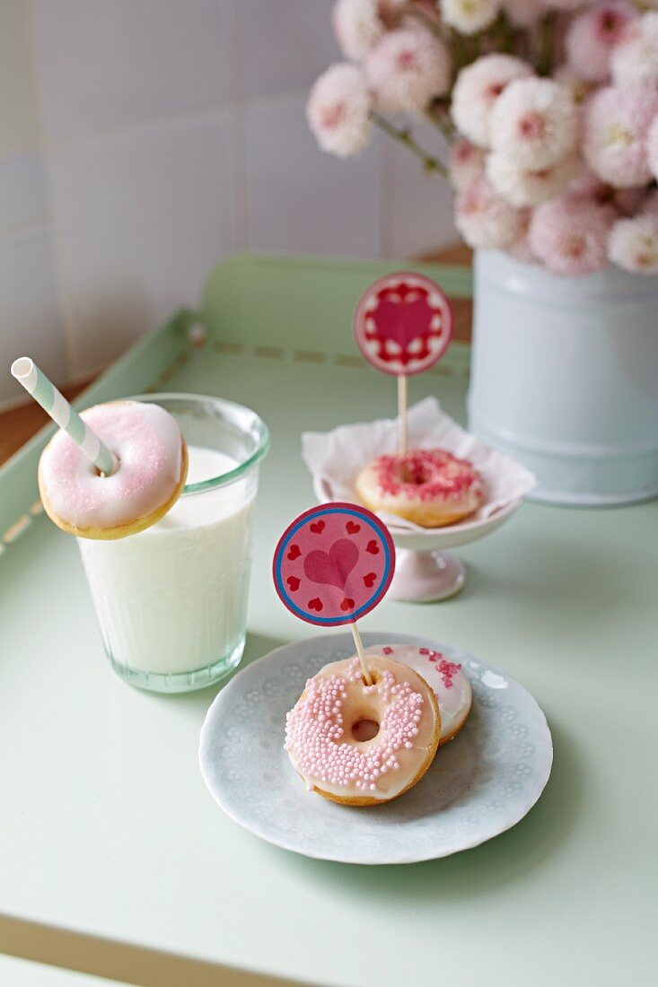 Mini doughnuts with heart decorations and a glass of milk