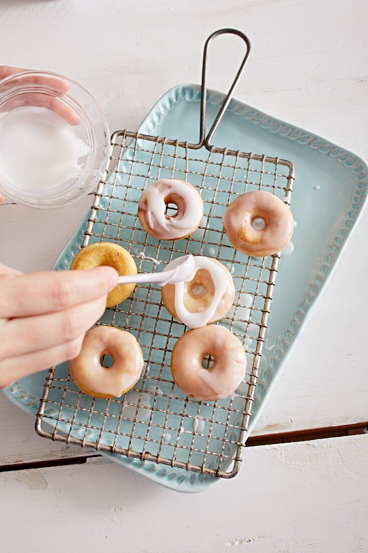 Decorating mini doughnuts with a sugar glaze