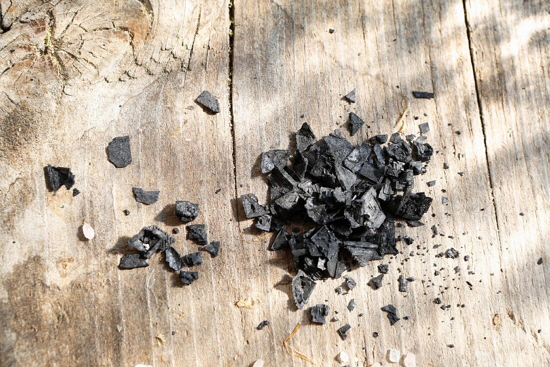 Grobes schwarzes Salz auf Holzuntergrund