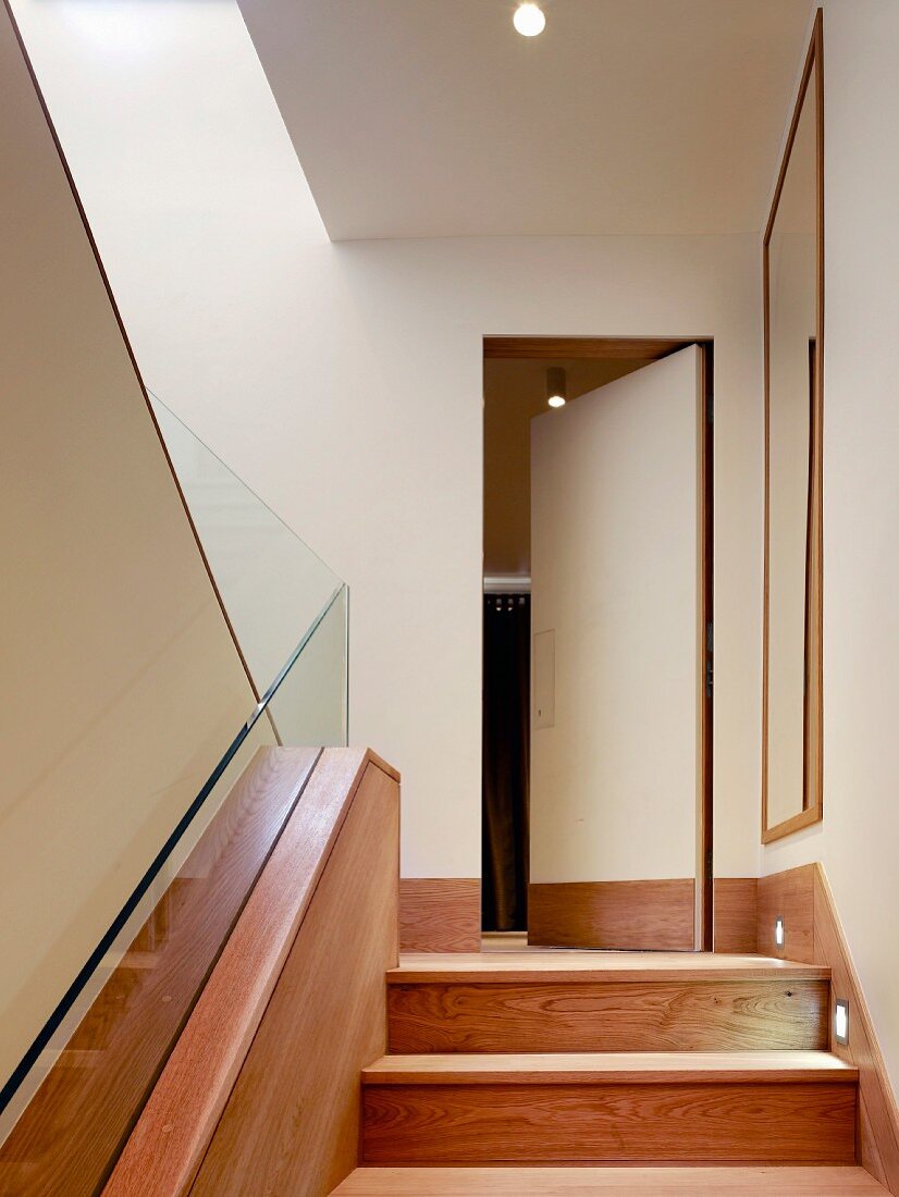 Wooden staircase leading to hidden door with wooden skirting board