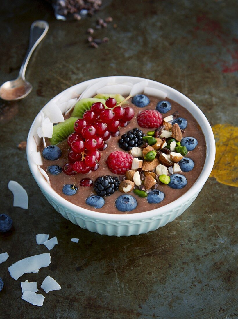 Chocolate and banana bowl with fresh berries and nuts