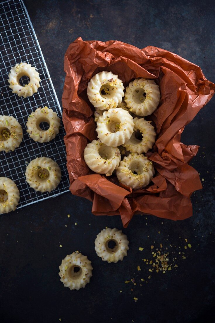 Vegan mini ring-shaped 'Gugelhupf' cakes with icing and pistachios