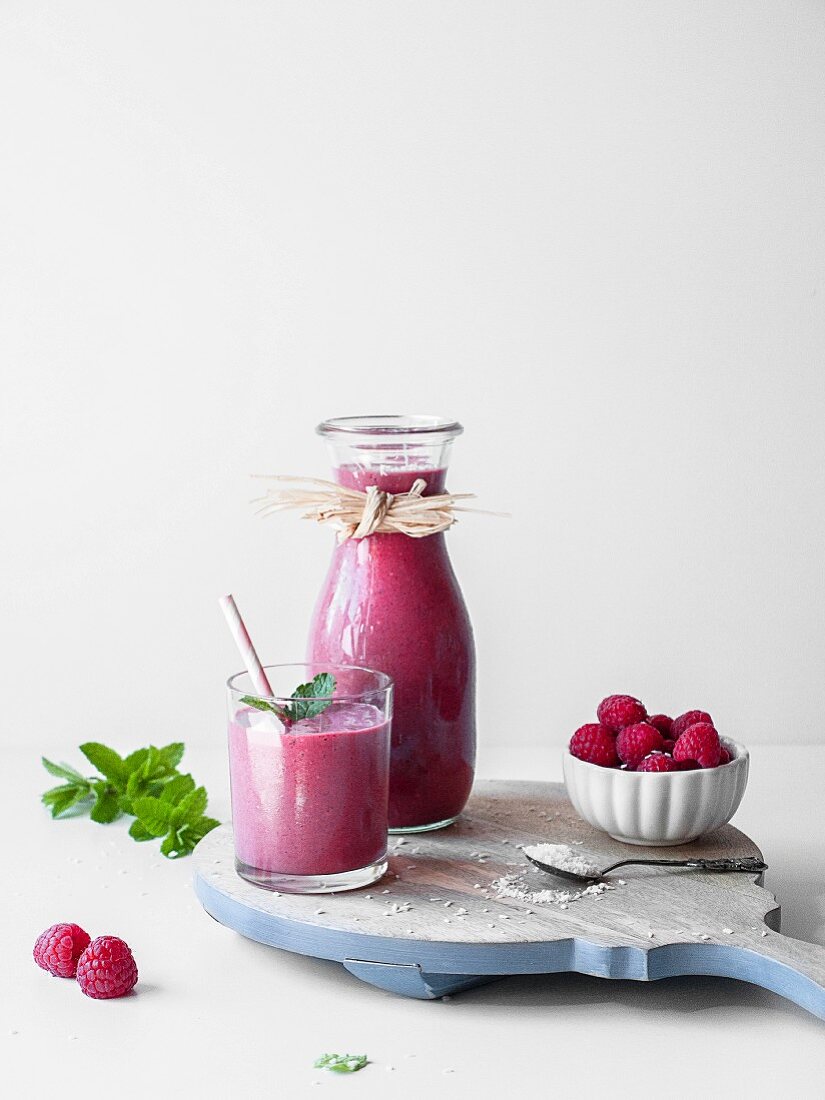 Pinkfarbener Lakritz-Himbeersmoothie serviert in Glas und Karaffe