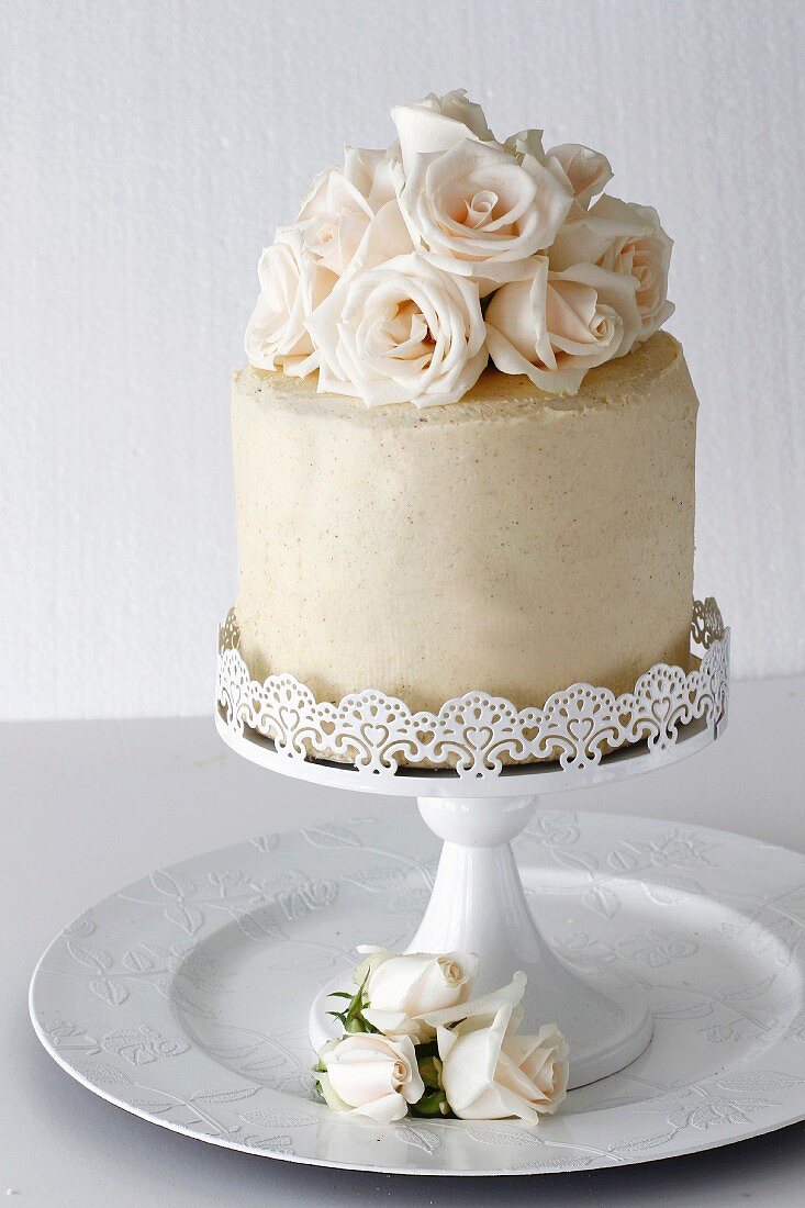 Festliche Vanilletorte mit Rosen auf Kuchenständer