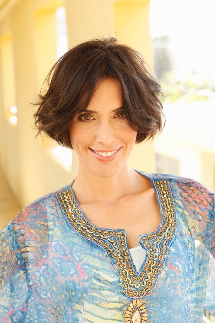 Brunette woman wearing patterned, embroidered tunic