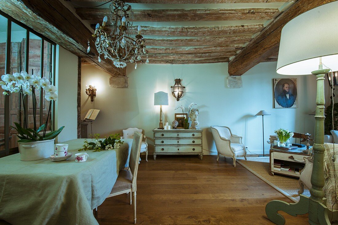 Rustic wood-beamed ceiling and antique furniture in renovated period building with historical ambiance