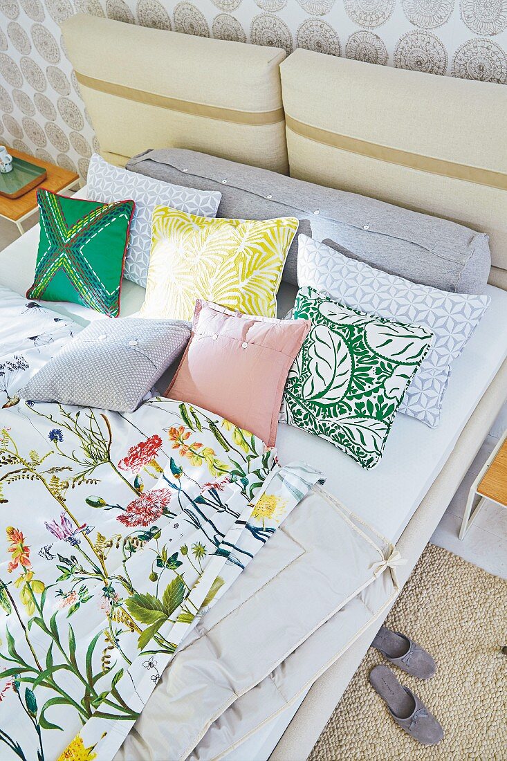 Blick auf Doppelbett mit Blumen-Bettwäsche und Kissen