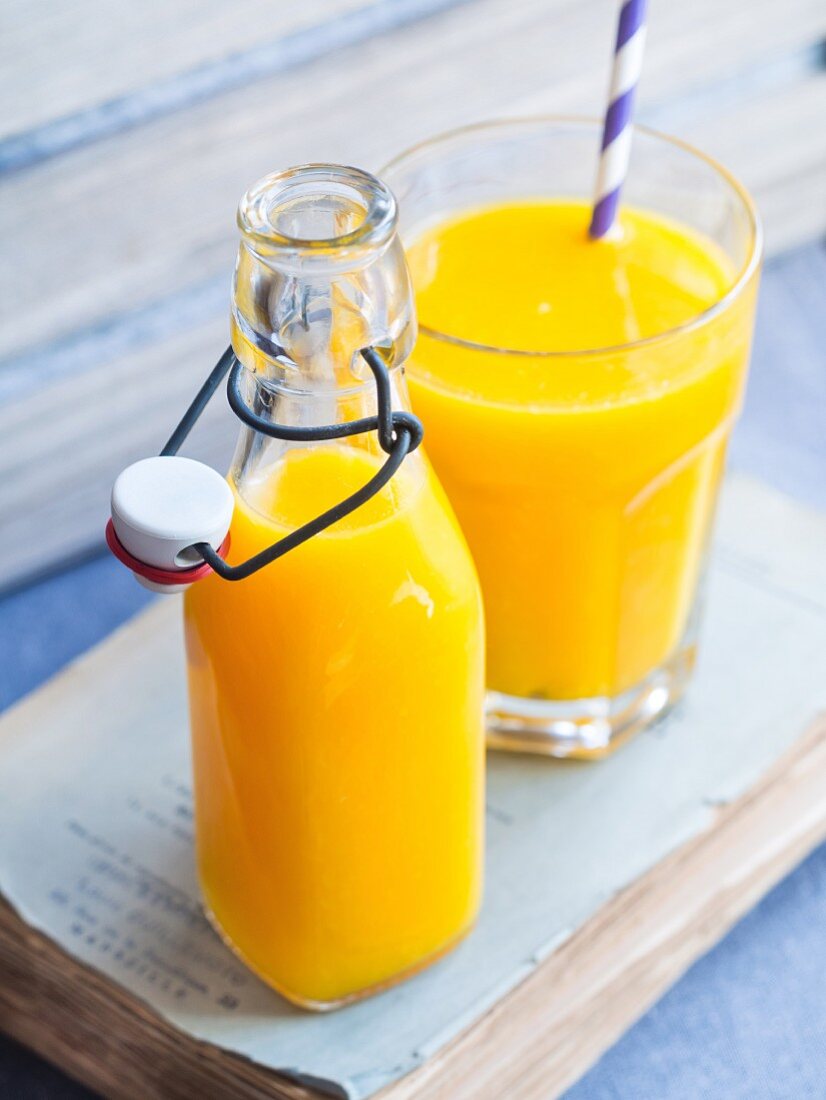 Frisch gepresster Orangensaft in Flasche und Glas