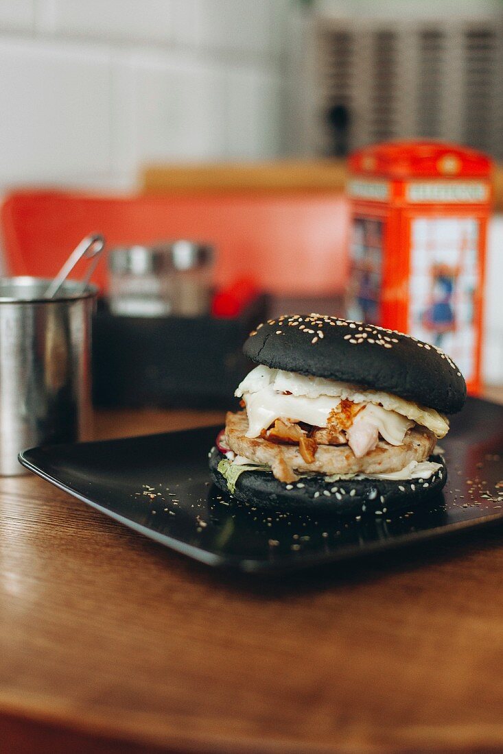 Black burger with cheese, tomatoes and lettuce