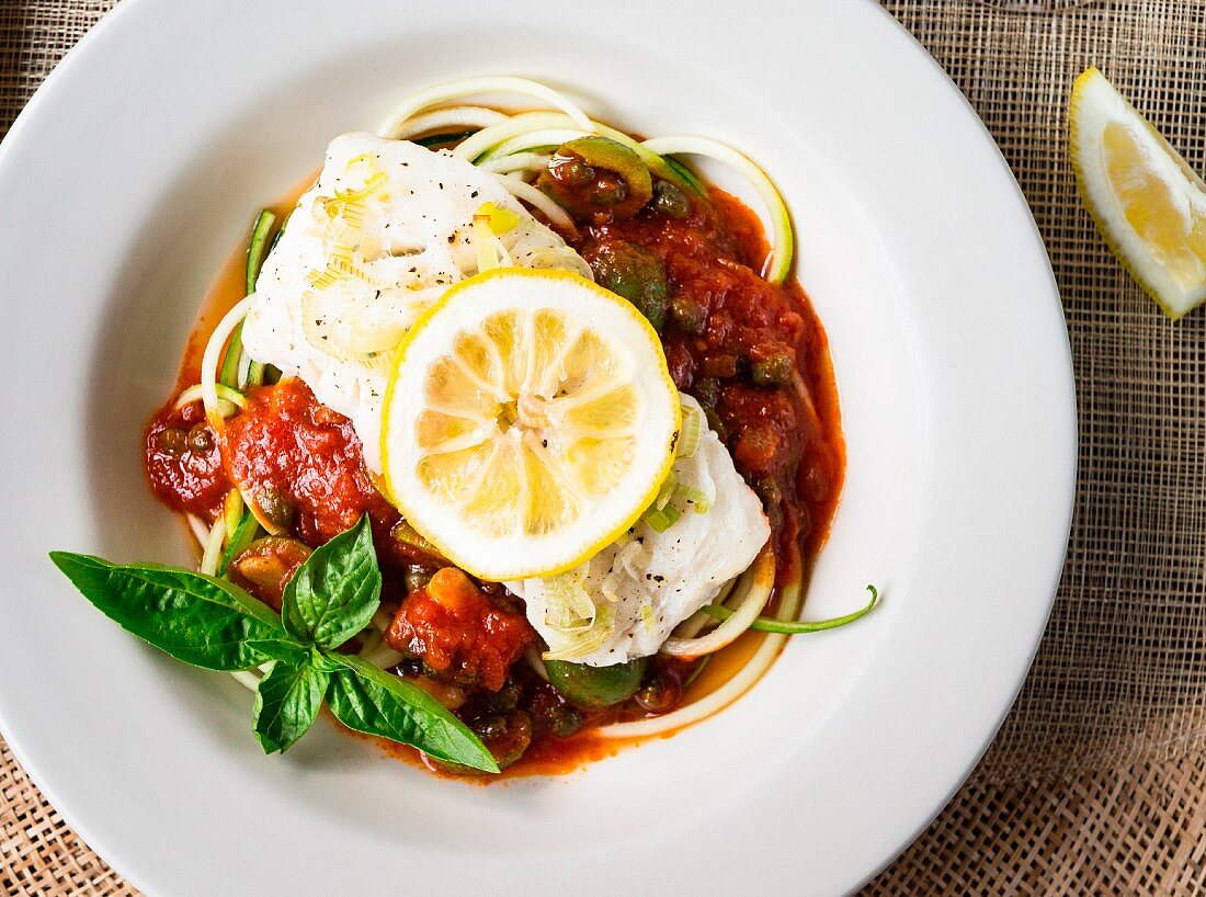 A cod fillet with tomato sauce and zoodles (zucchini noodles)