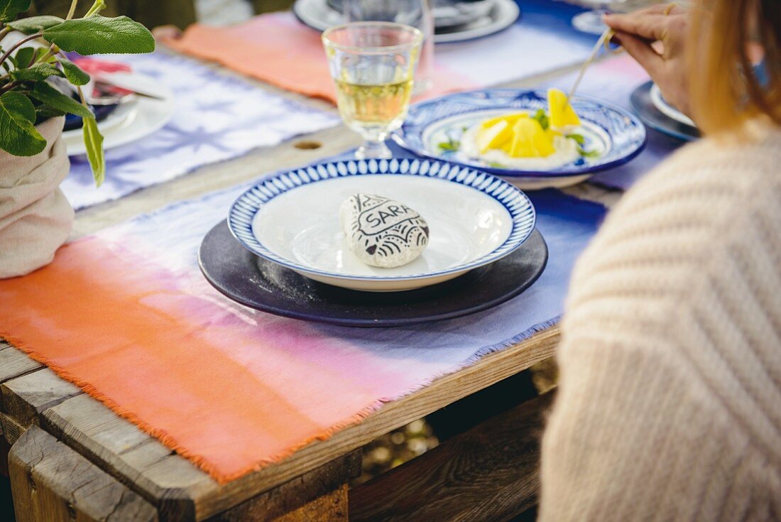 Place setting with batik place mat and name written on pebble