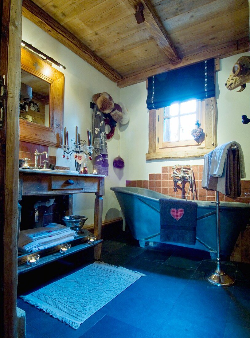 Free-standing zinc bathtub in rustic bathroom