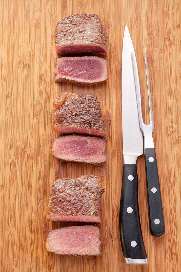 The stages of cooking steak (raw, rare, pink, well done)